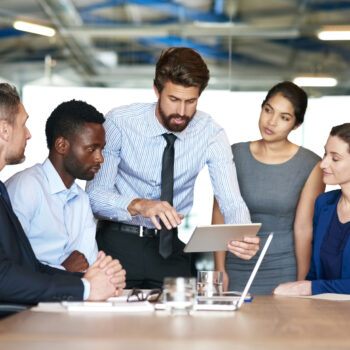 Shot of a group of businesspeople discussing something on a digital tablet